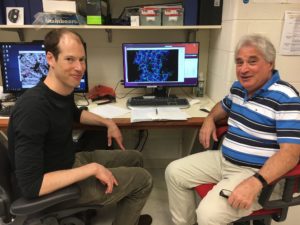 Peter M. Kasson, MD, PhD, (left) and Edward H. Egelman, PhD, with the indestructible virus displayed on screen.