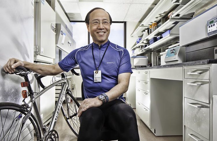 Zhen Yan, PhD, in his lab with his bike