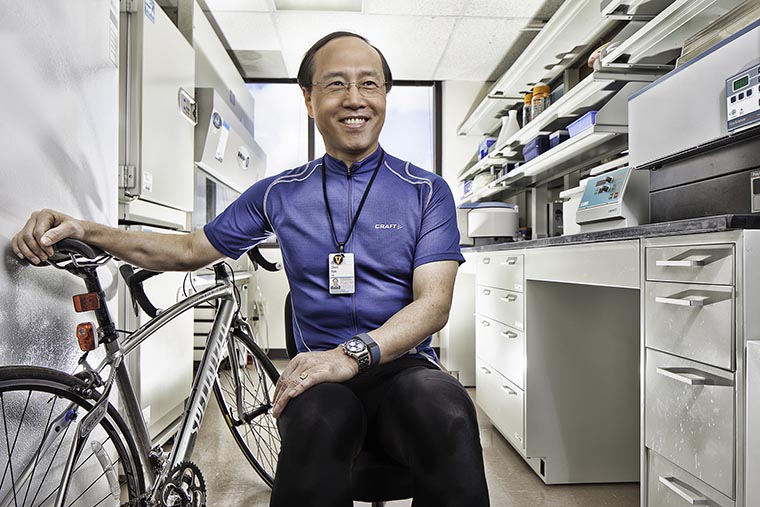 Zhen Yan, PhD, in his lab with his bike