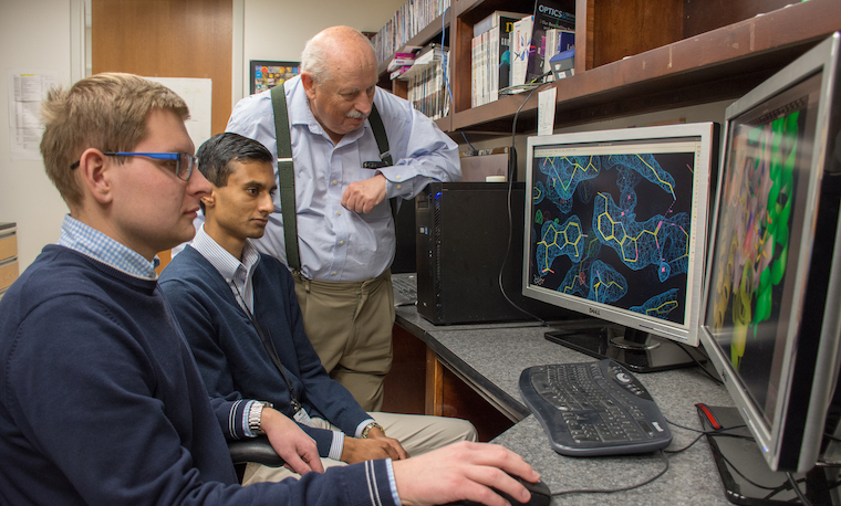 Second-year graduate student Mateusz Czub and undergraduate chemistry student Barat Venkataramany analyze a testosterone binding site and discuss the possible medical implications of their finding with Wladek Minor, PhD.