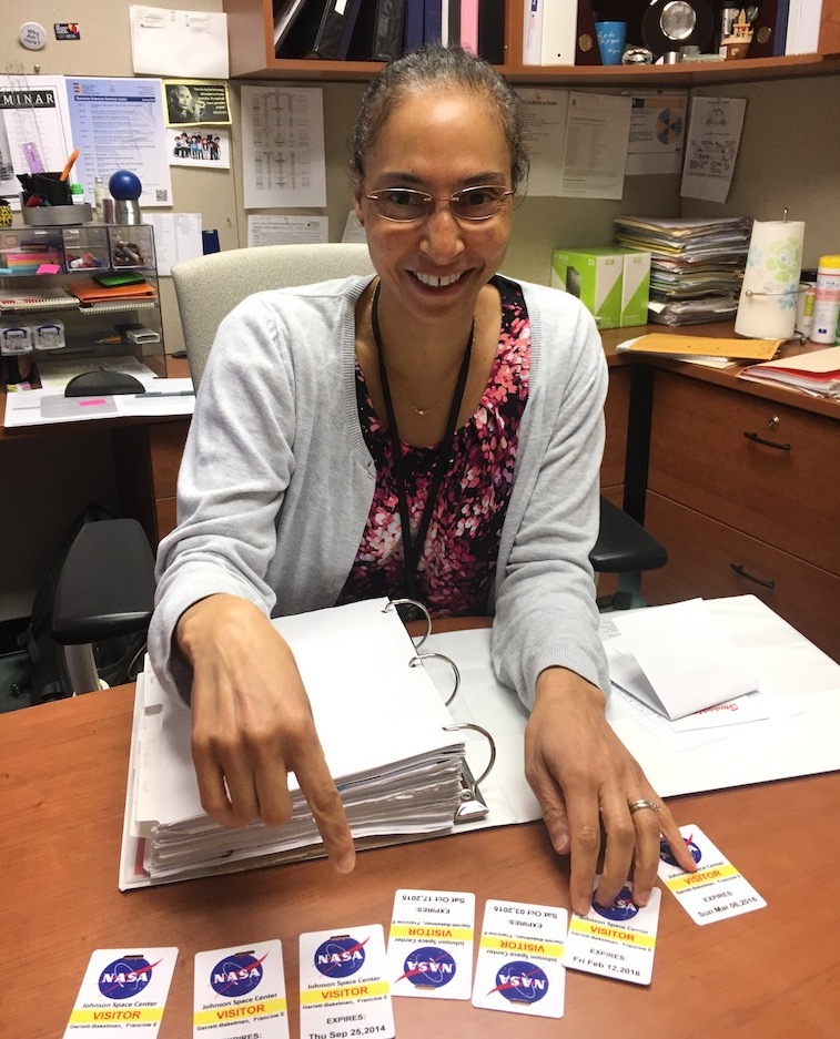 Francine Garrett-Bakelman, MD, PhD, of the UVA Cancer Center, displays visitor passes she accumulated at the Johnson Space Center in Houston.