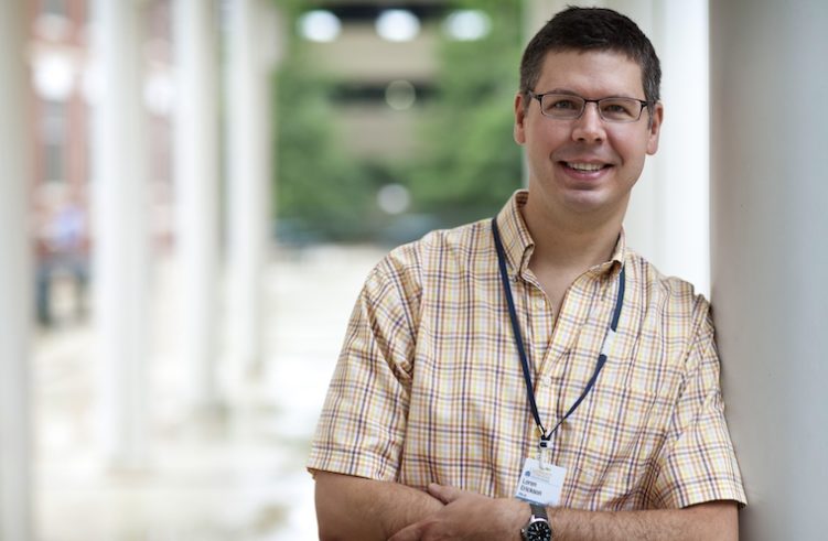 Loren Erickson leans against a white pillar.