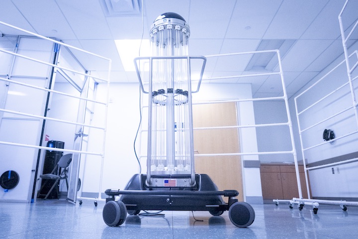 UVA's new mask-disinfecting robot looks like tall clear tubes mounted on wheels.