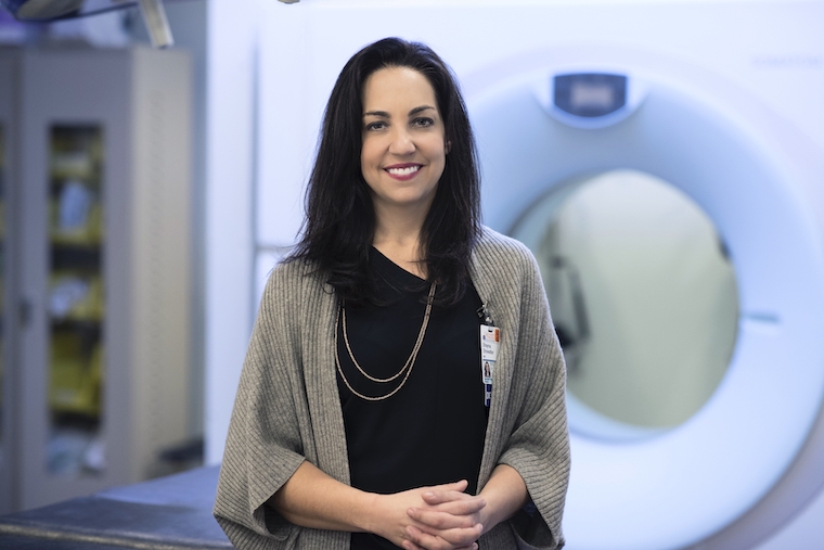 Shayna Showalter stands in front of imaging equipment.