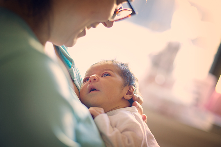 A mother cuddles a newborn.