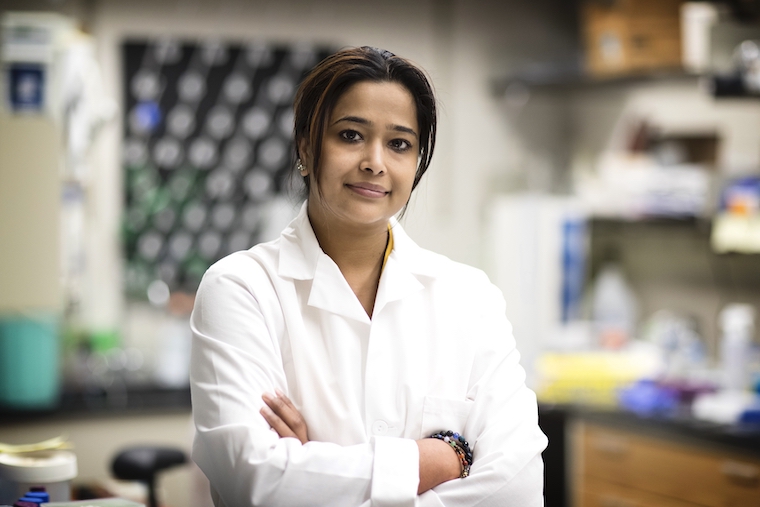 Sanchita Bhatnagar wears a white coat in her lab.