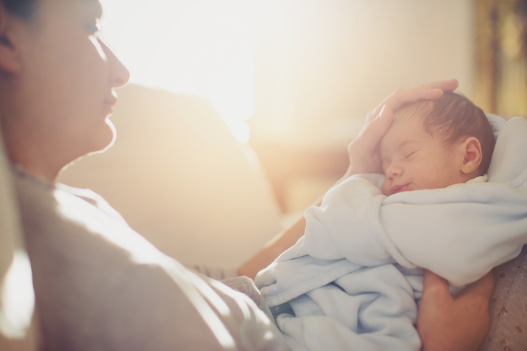 A woman looks lovingly at her newborn.