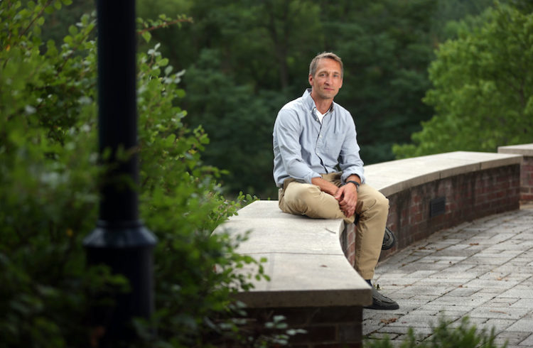 Jochen Zimmer sits amid greenery outside his lab at UVA.