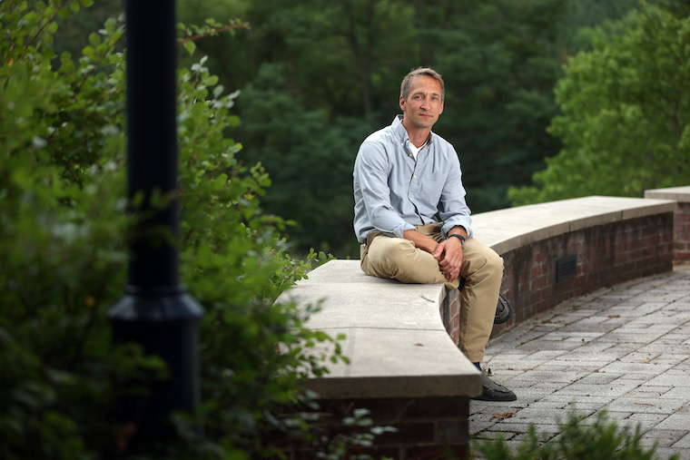 Jochen Zimmer sits amid greenery outside his lab at UVA.