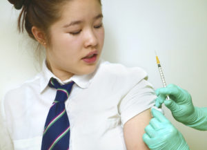 A schoolgirl receives a vaccine.