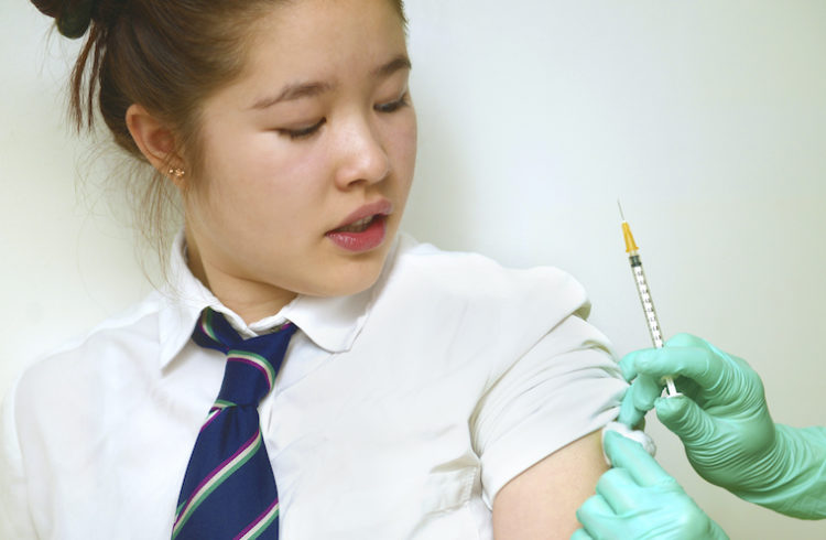 A schoolgirl receives a vaccine.