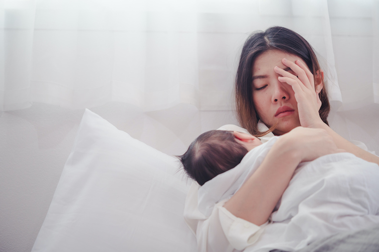 A woman holds her baby while struggling with depression.