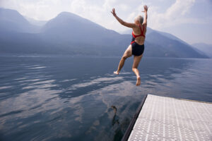 Female Baby Boomer jumps into a lake