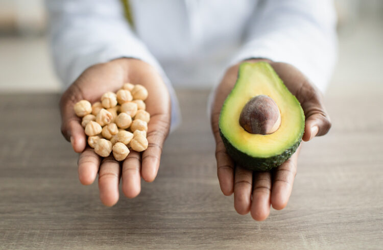 Hands holding an avocado and nuts