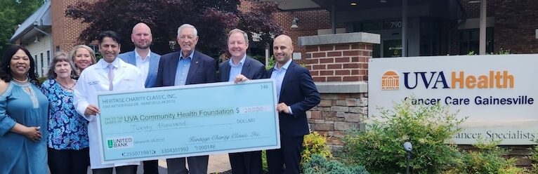 UVA Health team members hold a large presentation check