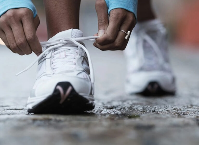 a runner lacing up shoes