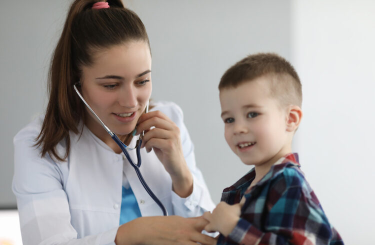 Pediatrician listens to small boy's lungs