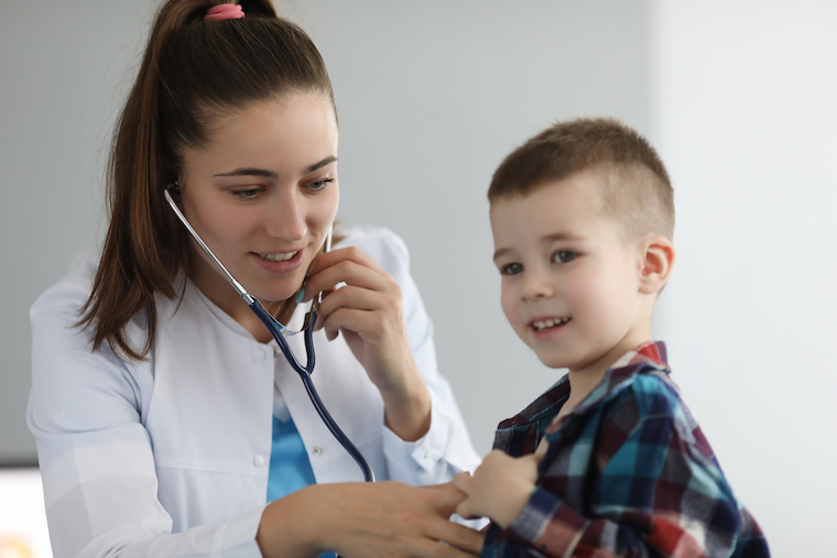 Pediatrician listens to small boy's lungs