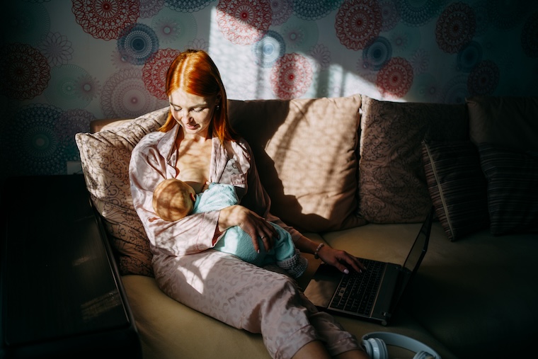 Mother breastfeeding in dimly lit room