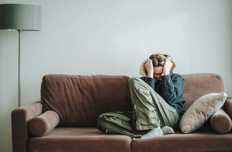 Young woman suffering symptoms on a sofa