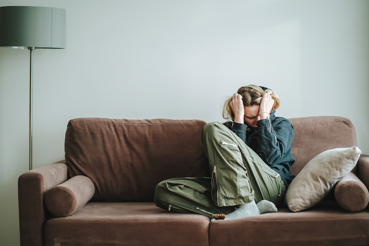 Young woman suffering symptoms on a sofa