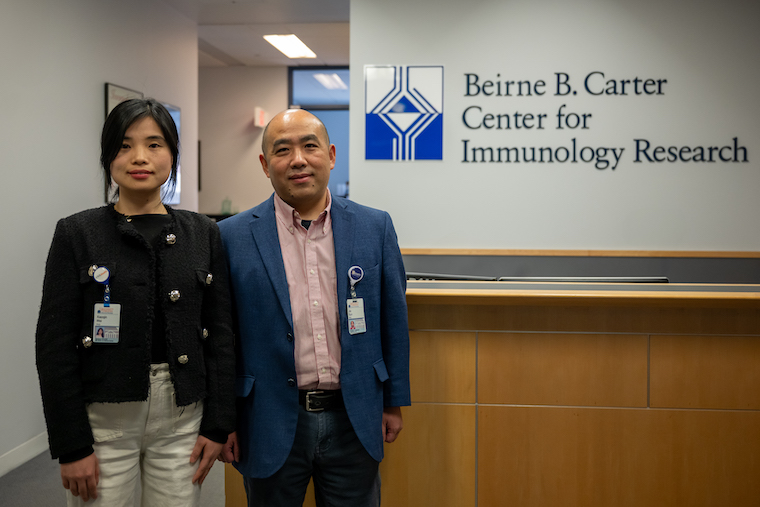 Xiaoqin Wei, PhD, and Jie Sun, PhD, outside UVA's Carter Center for Immunology Research