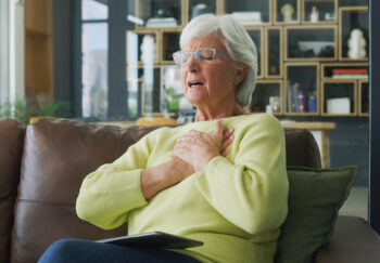 Woman suffering chest pain on couch