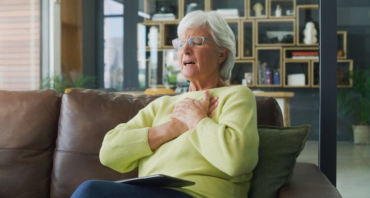 Woman suffering chest pain on couch
