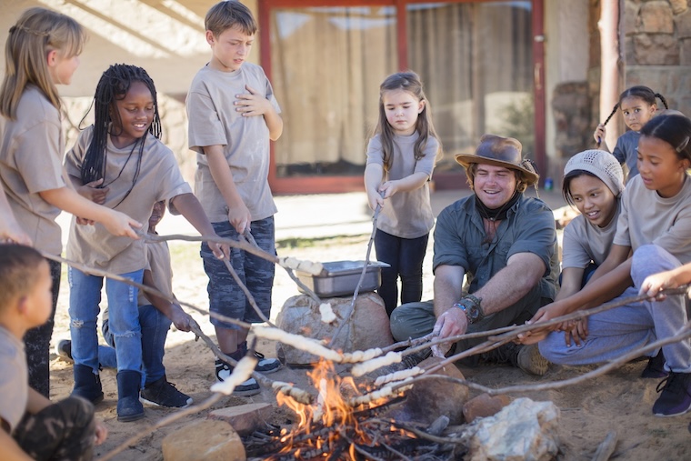 Kids roast marshmallows at summer camp